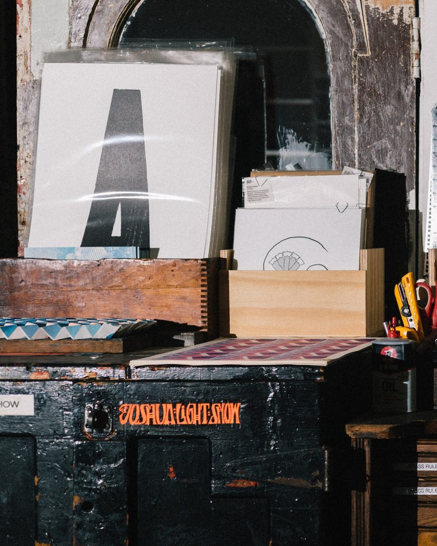 Letterpress-printed sheets and prints stacked at a print shop counter
