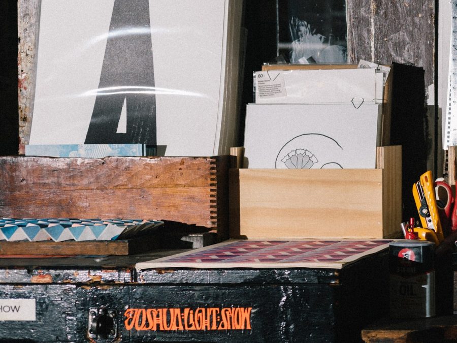Letterpress-printed sheets and prints stacked at a print shop counter